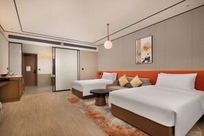 A hotel room with two beds, a sofa, a small table, and a wall-mounted artwork. - Hilton Garden Inn Chengdu Jinsha Site Museum (Chengdu)