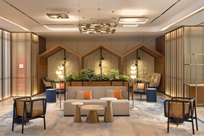A modern lobby with a central seating area, multiple tables, and a decorative ceiling. - Hilton Garden Inn Chengdu Jinsha Site Museum (Chengdu)