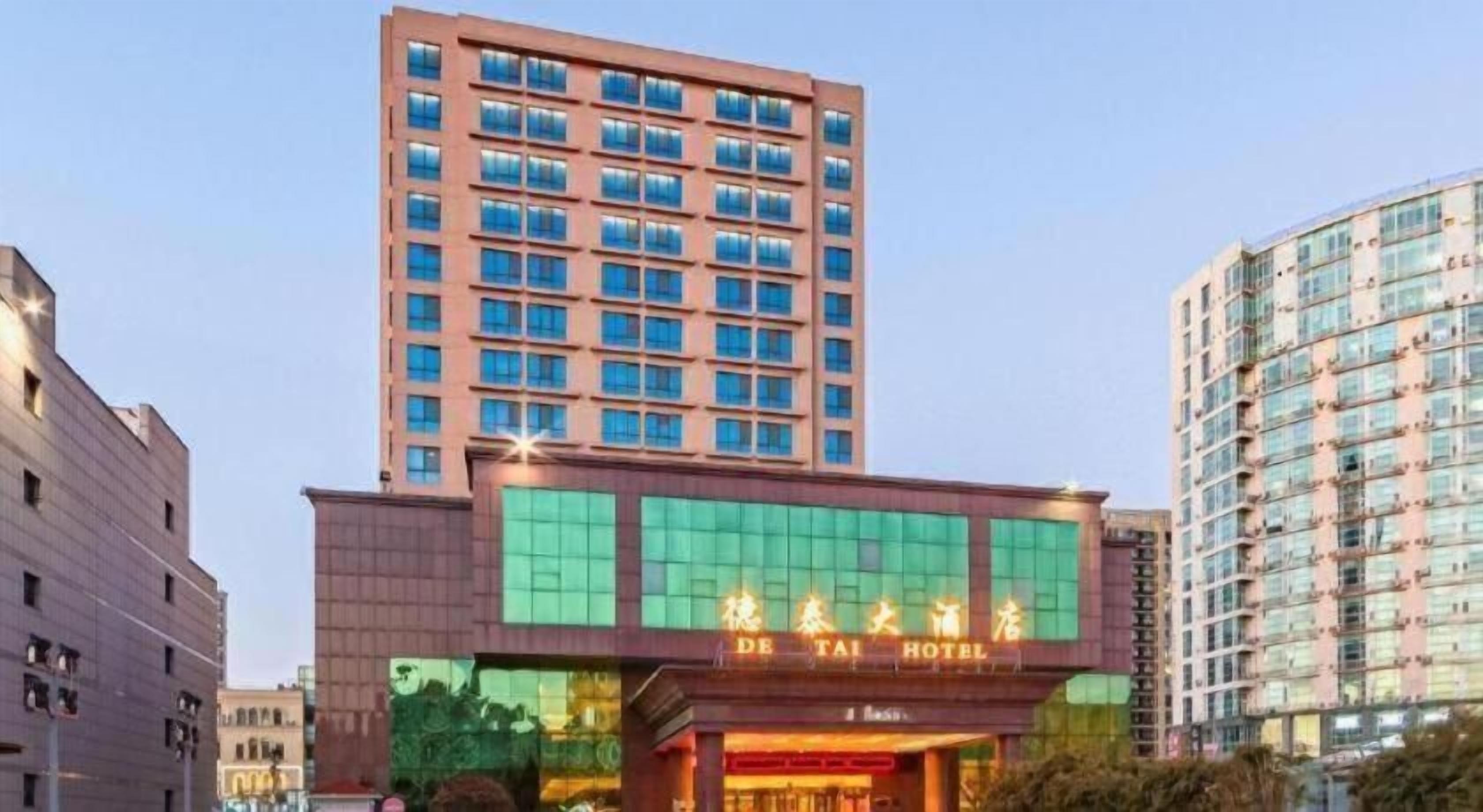 Un hotel con fachada moderna, amplias ventanas y un letrero llamativo.