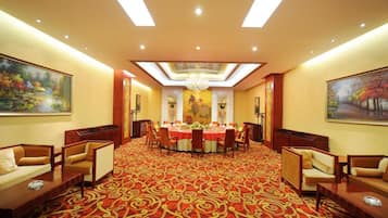 A conference room with a round table, chairs, and a carpeted floor.