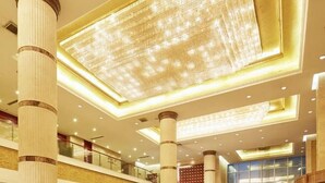 A multi-level hotel interior with a grand chandelier, multiple floors, and a central staircase. - Chengyang Detai Hotel (Qingdao)