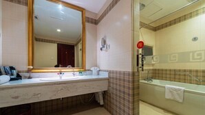 A bathroom with a large mirror, a sink, a toilet, and a shower area. - Chengyang Detai Hotel (Qingdao)