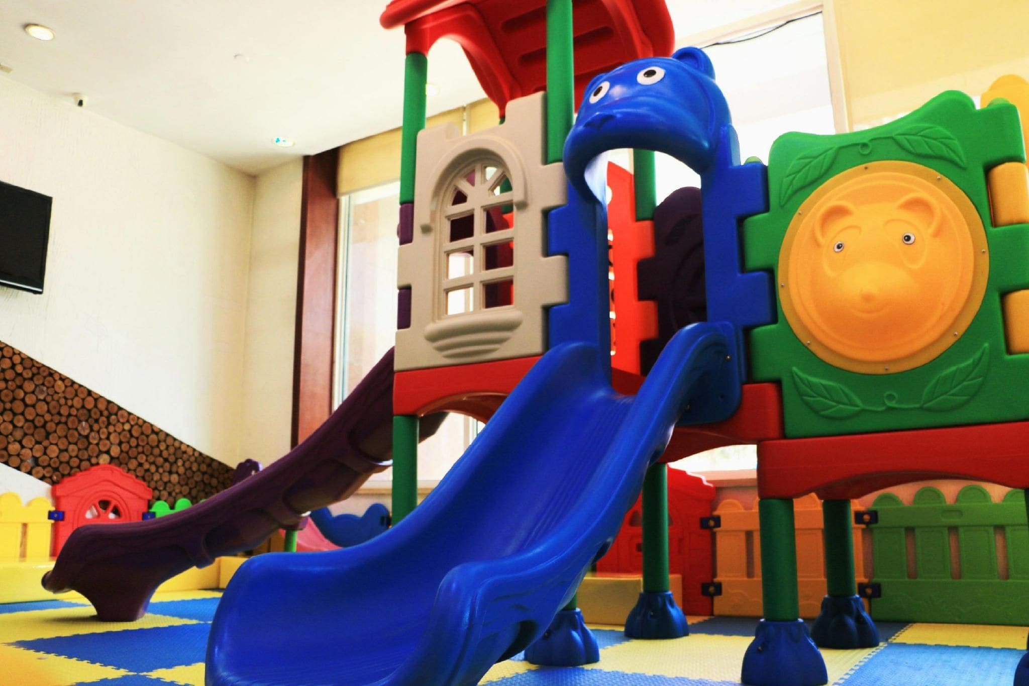 A children's play area with a slide and climbing structures.