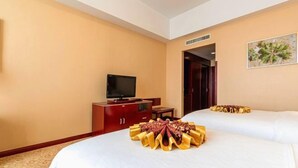 A hotel room with two beds, a TV, a wooden cabinet, and a framed picture on the wall. - Chengyang Detai Hotel (Qingdao)