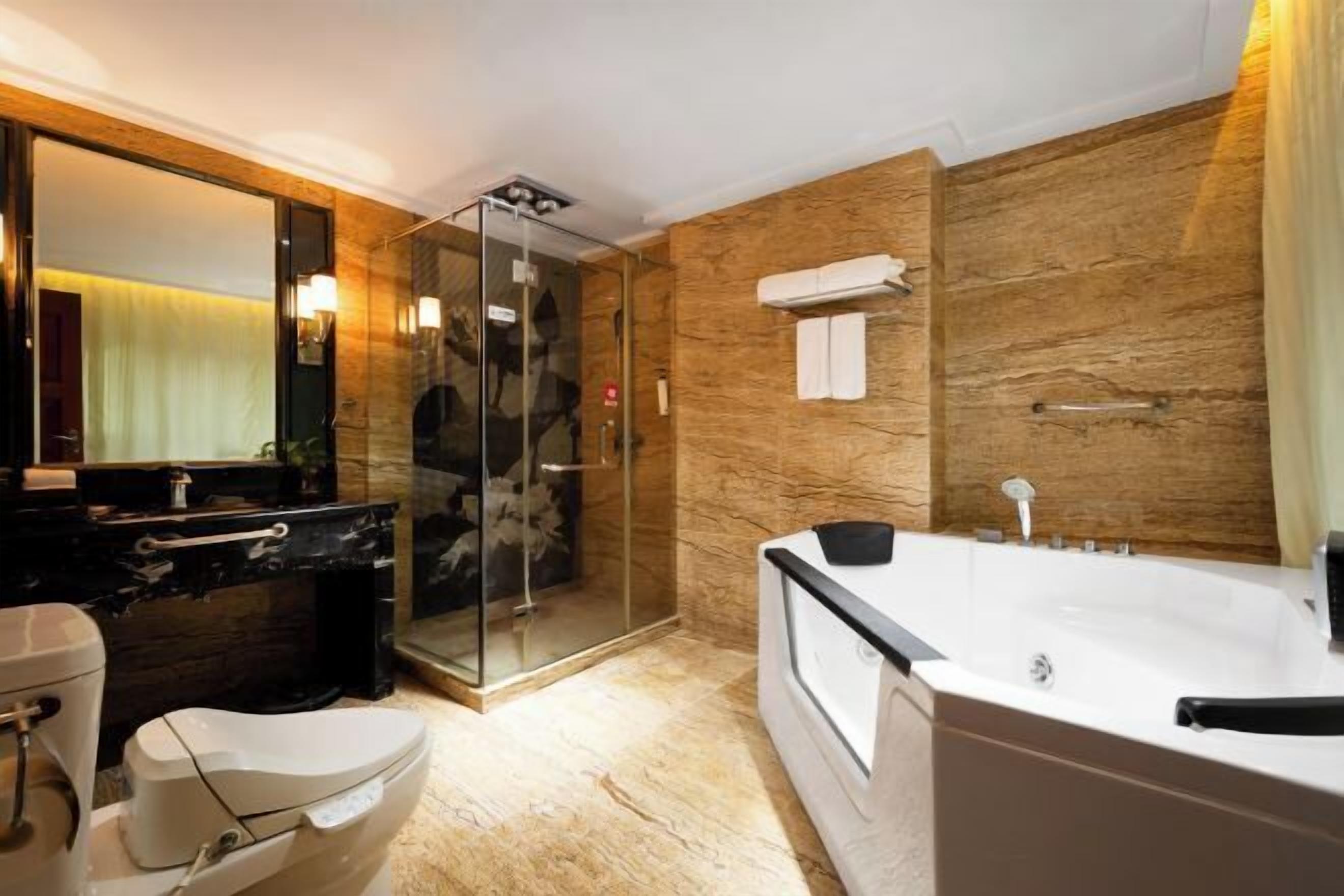 Un baño moderno con ducha de vidrio, una bañera grande y suelo de mármol.