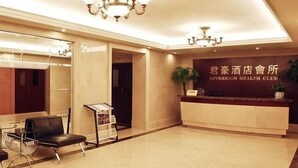 A hotel reception area with a reception desk, seating area, and a chandelier. - Chengdu Sovereign Hotel (Chengdu)