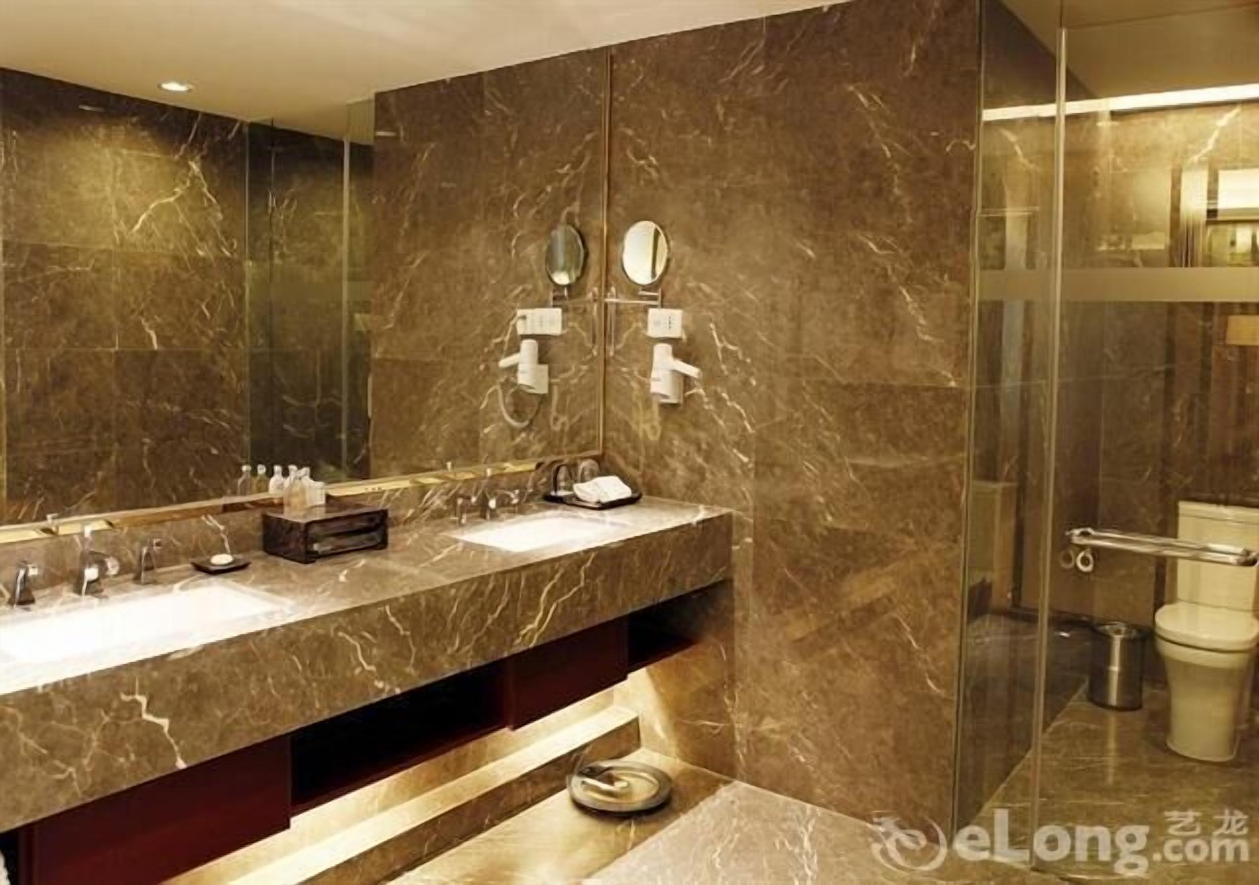 Une salle de bain moderne avec un meuble-lavabo en marbre, deux vasques et une douche à parois de verre.