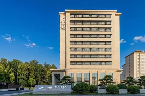 Um edifício de vários andares com uma placa indicando que é um hotel.