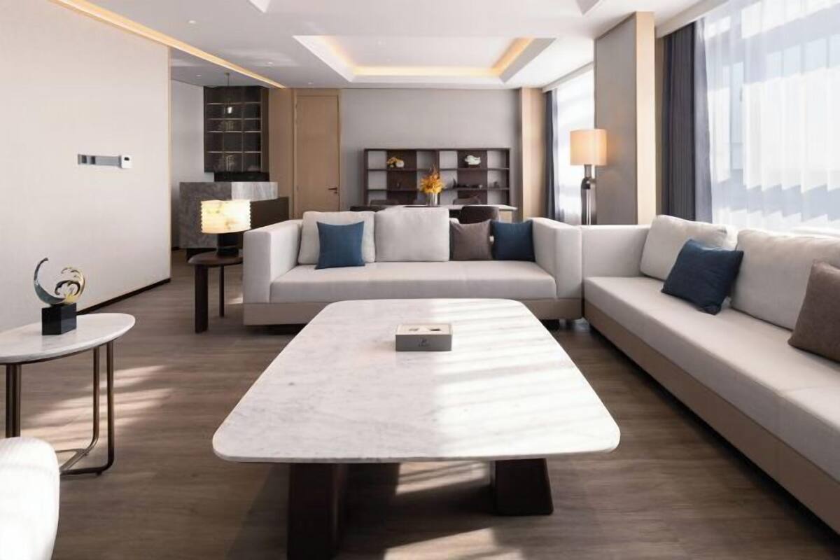 A modern living room with a sofa, a coffee table, and a lamp.
