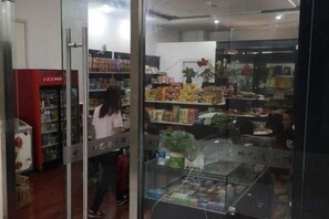 Ein Geschäft mit Regalen voller verschiedener Produkte, einer Glasvitrine und einem Kühlbereich.