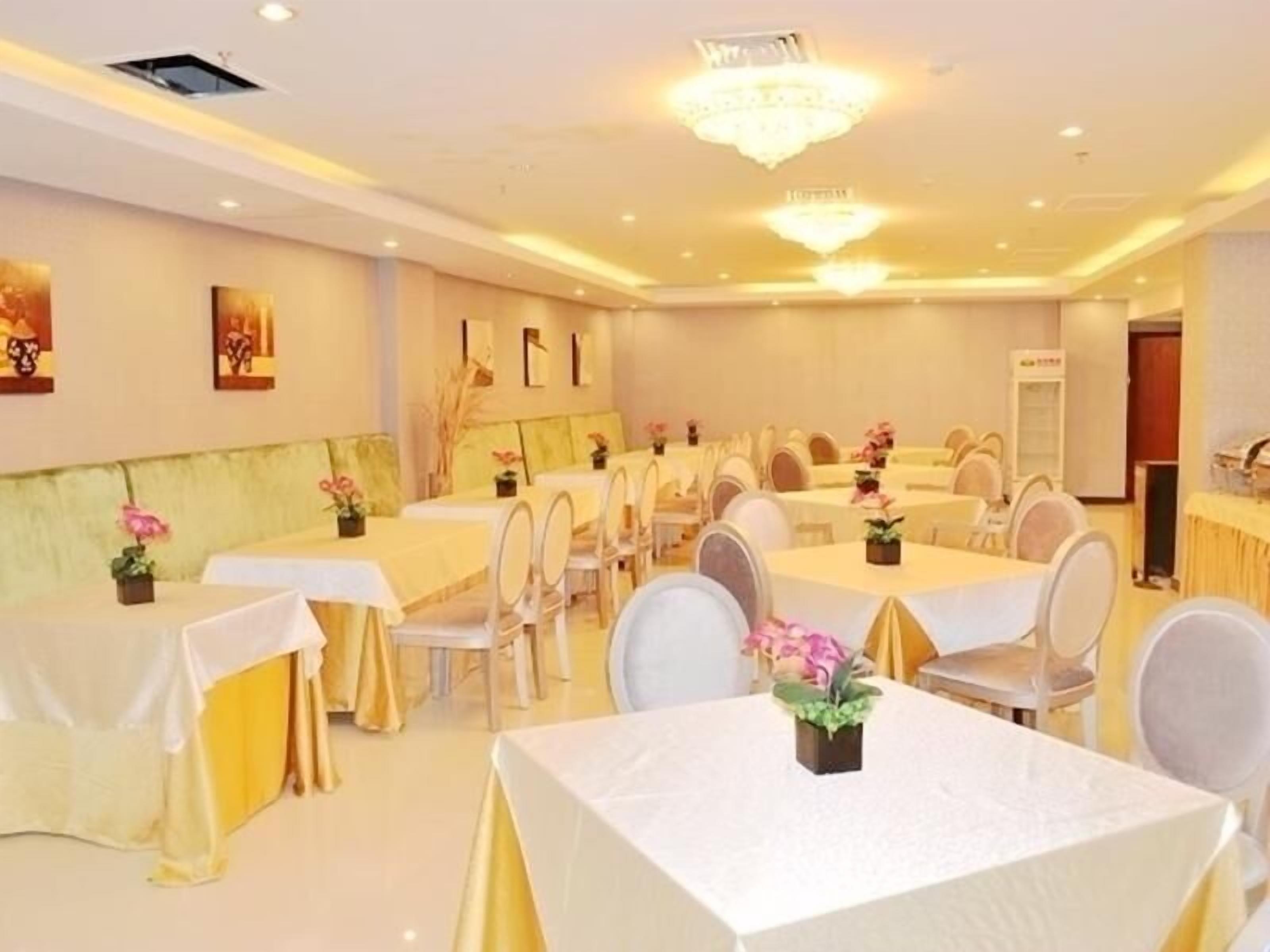 A banquet hall with round tables, white tablecloths, and chairs.