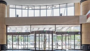 A hotel lobby with a revolving door, large windows, and a polished floor. - Zhong Ji Subaru Hotel (BEIJING)