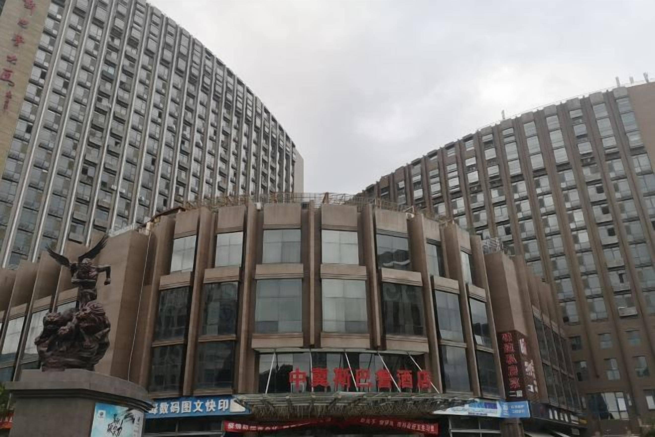 A multi-story building with a curved facade and large windows.