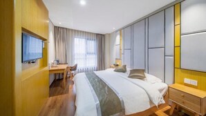 A hotel room with a bed, bedside table, TV, desk, chair, and a large window with curtains. - Zhong Ji Subaru Hotel (BEIJING)