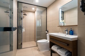 A modern bathroom with a glass-enclosed shower, a white toilet, and a vanity with a mirror. - Jin Tai Zi Hotel - Zhuhai (Zhuhai)
