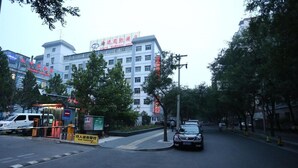 Un hôtel à étages, doté d’une entrée bien visible et d’un espace de stationnement.