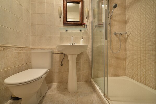 Une salle de bain avec des toilettes, un lavabo et une douche.