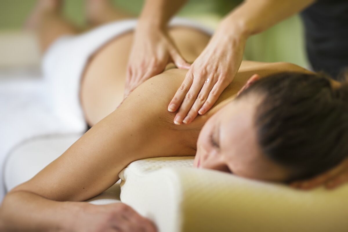 A person receiving a massage on a massage table.
