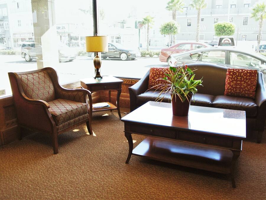 A living room with a sofa, armchair, coffee table, and a lamp.