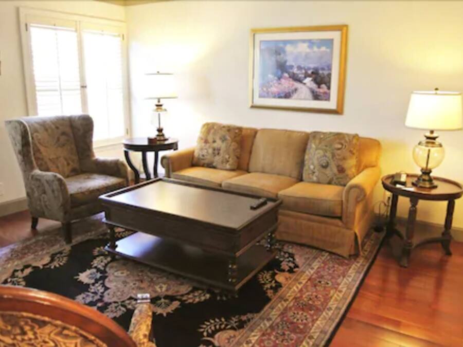A living room with a sofa, armchair, coffee table, and two side tables with lamps.