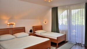 A room with two wooden beds, a nightstand, and a wall-mounted light fixture. - Nature Hotel Lukanc Bled (Bled)