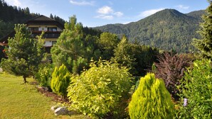 A two-story building with a balcony, surrounded by a variety of trees and shrubs. - Nature Hotel Lukanc Bled (Bled)