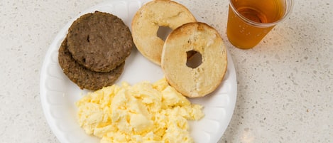 En tallrik med rörägg, två bagels och ett glas te.