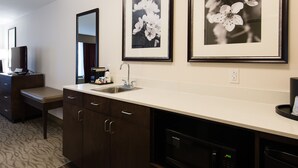 A modern bathroom with a dark wood vanity, a sink, and a mirror. There are framed black and white floral photographs on the wall. - Holiday Inn Express & Suites Aiken by IHG (Aiken)