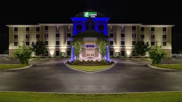 A Holiday Inn Express & Suites hotel with a symmetrical facade, large windows, and a central entrance.