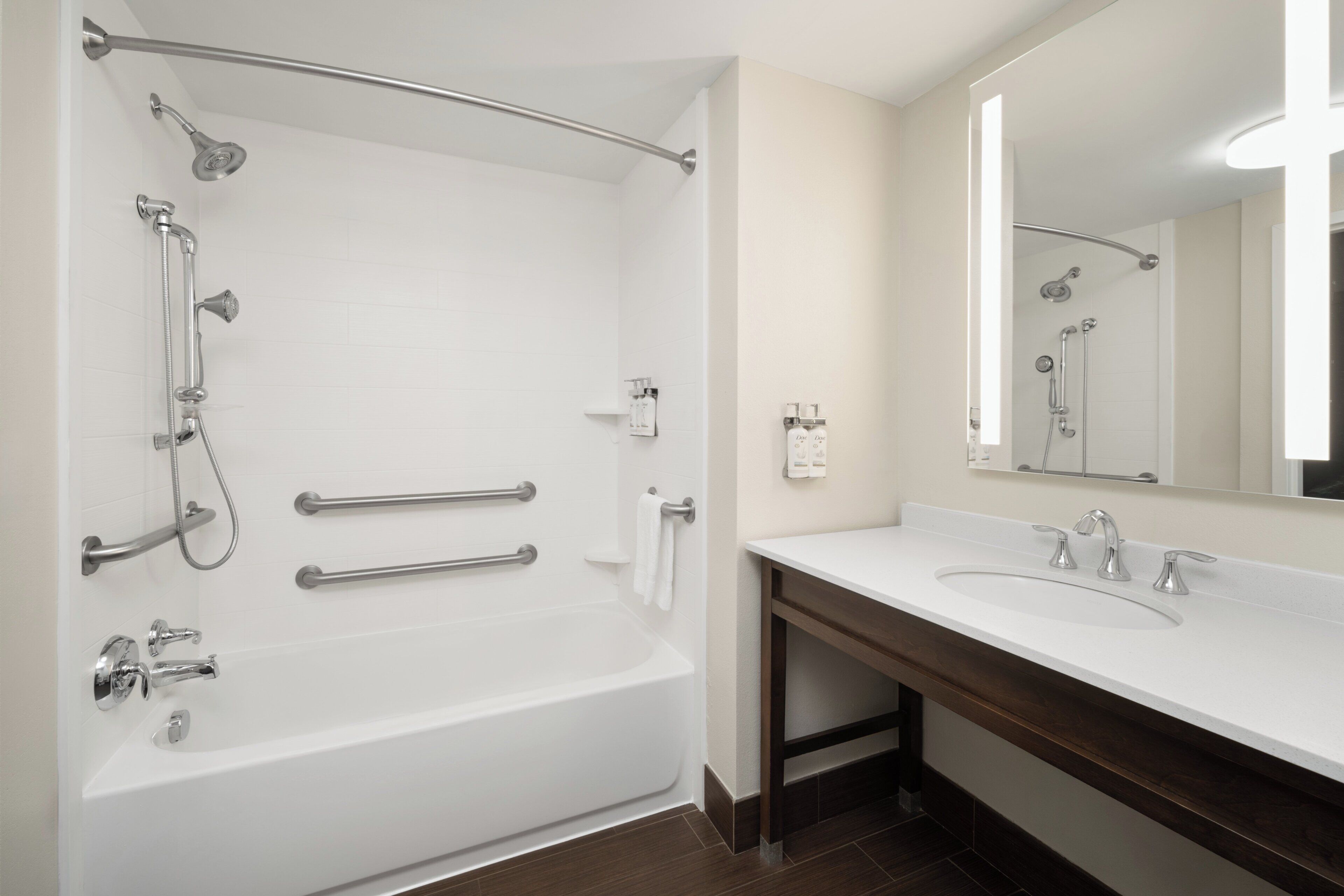 A modern bathroom with a bathtub, shower, and vanity.