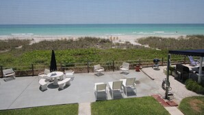 Eine Terrasse mit Sitzgelegenheiten mit Blick auf einen Strand.