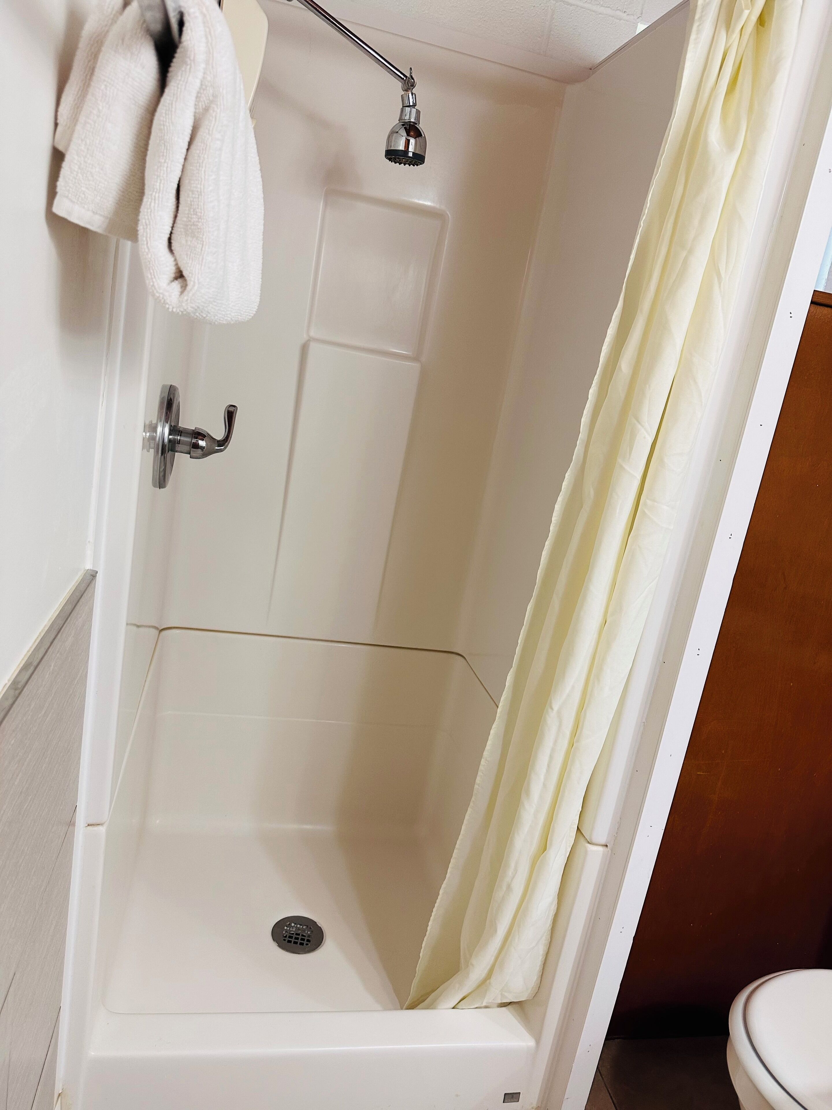 A shower with a white tub, a showerhead, and a curtain.