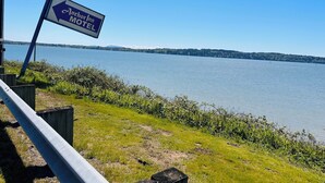 Schild für das Anchor Mor Inn, das auf einen See zeigt, mit freiem Blick auf das Wasser und das entfernte Ufer.