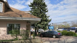 A motel with a single-story structure, a parking area, and a visible sign for the Clarkson Village Motel. - Clarkson Village Motel (Mississauga)