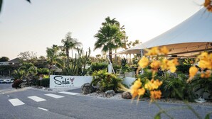 A restaurant with a signboard, outdoor seating, and a tent structure. - Chogogo Dive & Beach Resort Curacao (Jan Thiel)