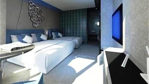 A modern hotel room with a large bed, a desk, and a TV. - Blutique Hotel (Bangkok)