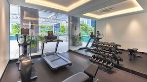 A modern gym with cardio equipment, dumbbells, and a treadmill. - Orchid Hotel (Singapore)