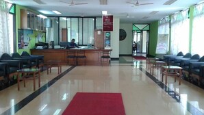 A reception area with a receptionist desk, seating arrangements, and a red carpet. - Old Goa Residency (Panaji)