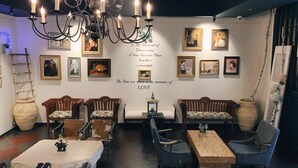 A cozy dining area with a chandelier, wooden furniture, and wall-mounted artwork. - Le Mong Hotel (Seoul)