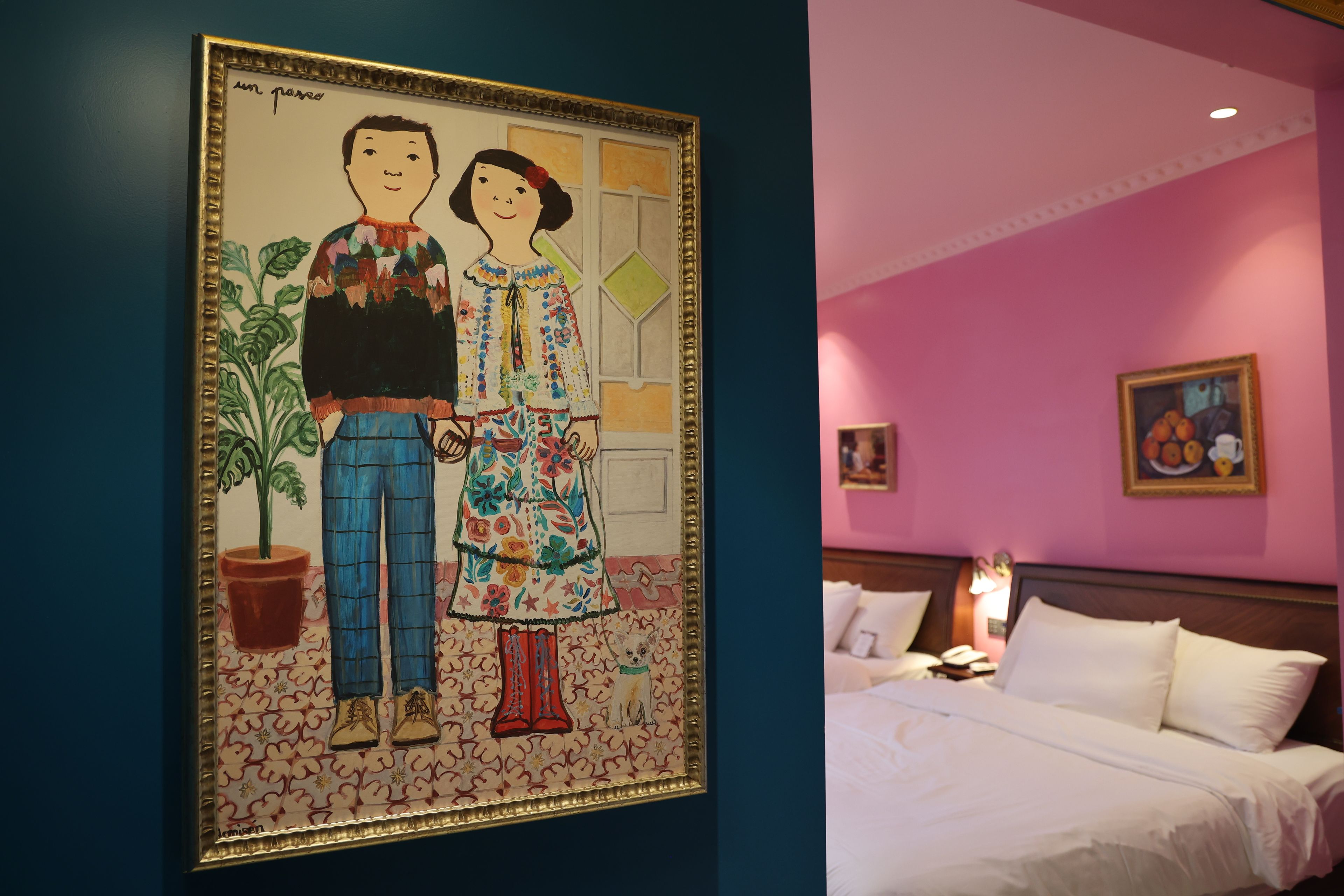 Ein Hotelzimmer mit einem Bett, einem Nachttisch, einer Lampe und einem Bild an der Wand.
