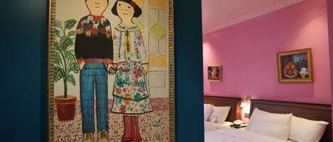 Ein Hotelzimmer mit einem Bett, einem Nachttisch, einer Lampe und einem Bild an der Wand.