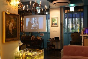 Una habitación acogedora con una pantalla de proyector, un acuario de cristal y una zona de estar cómoda.