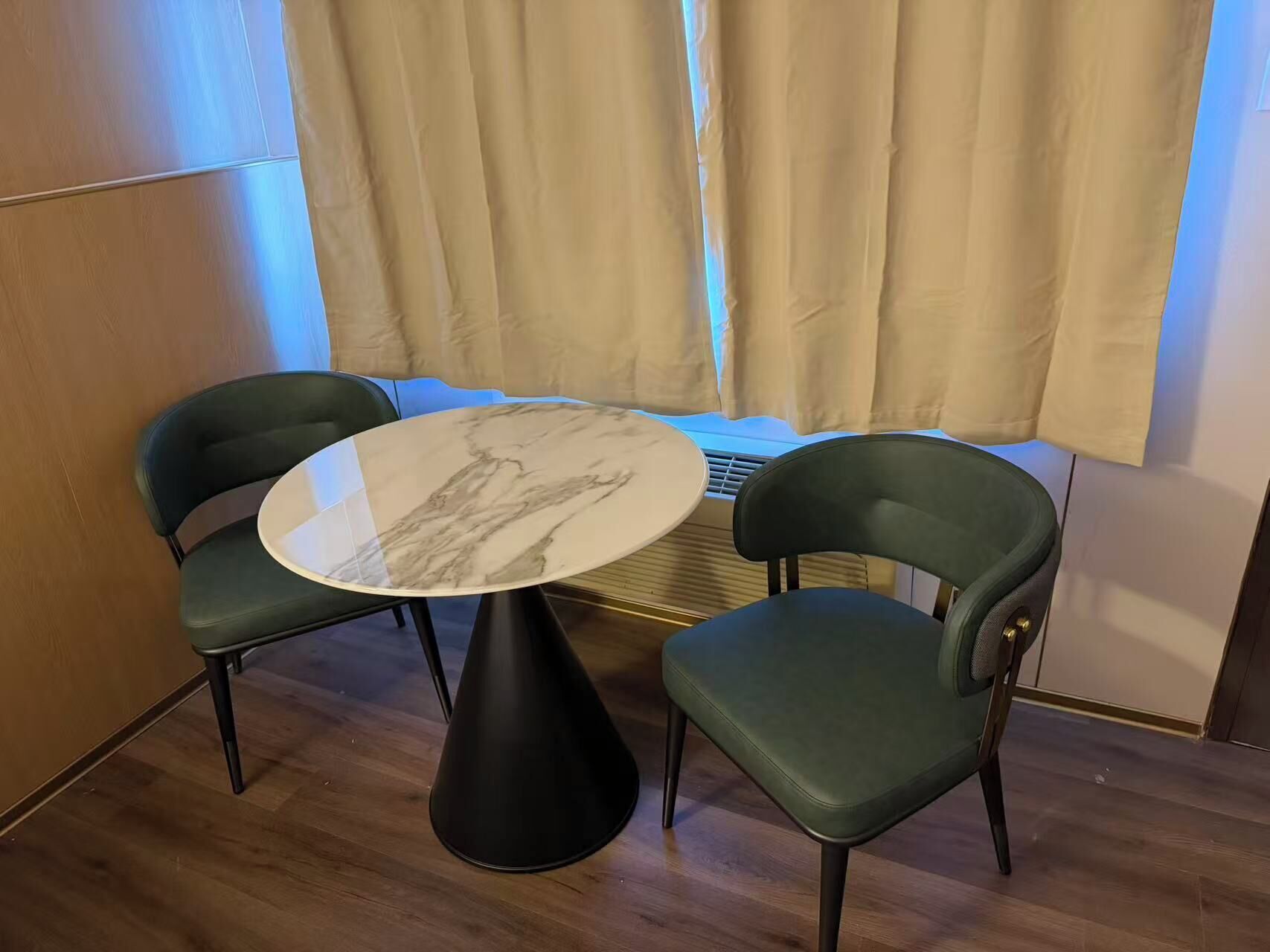 A dining area with a round table and two chairs.
