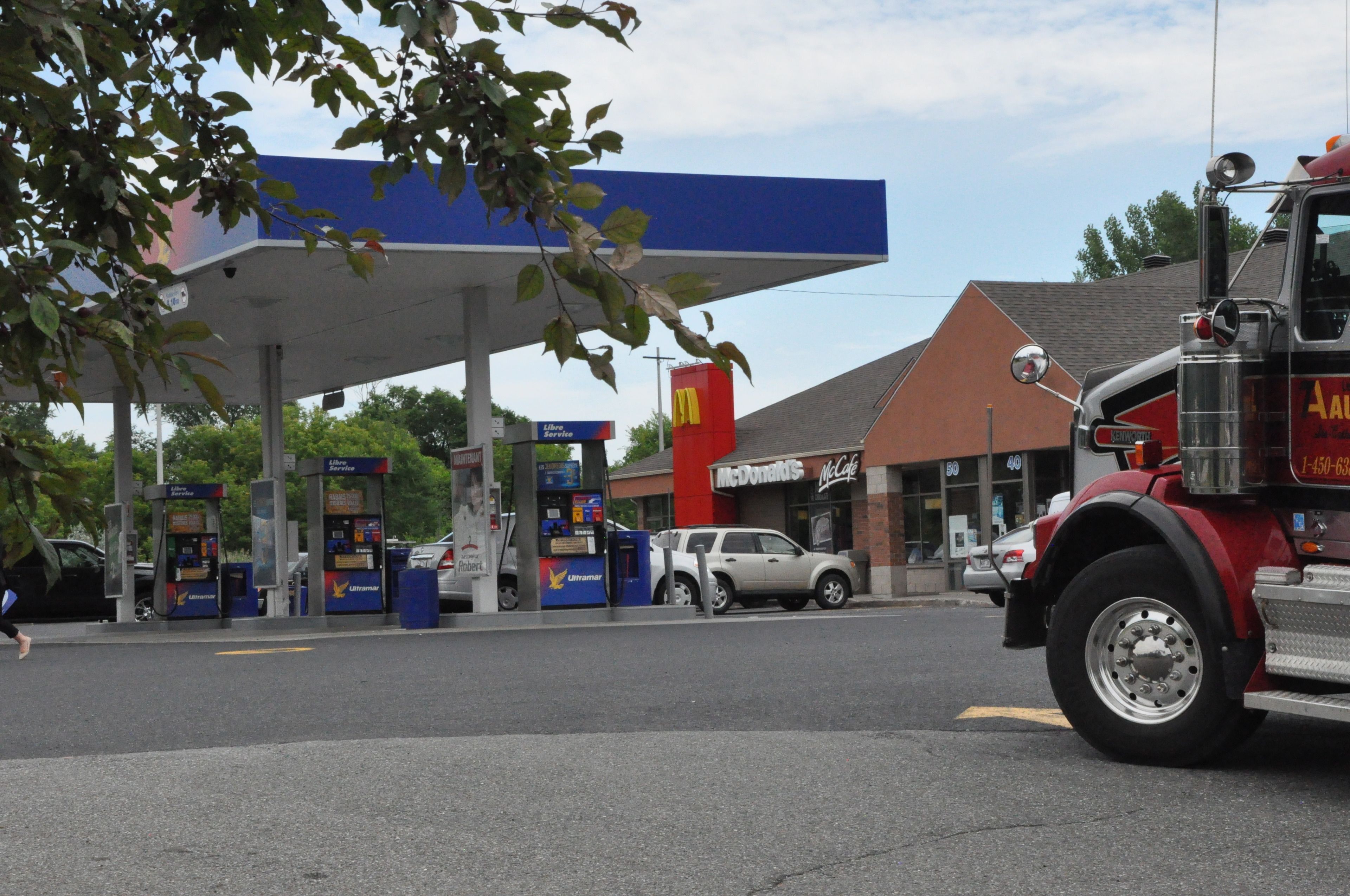 A gas station with a McDonald's and a fire truck parked nearby.