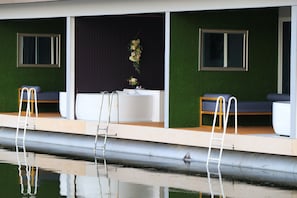 A modern spa area with a large bathtub, two seating areas, and a small window. - Raya Buri Resort (Si Sawat)