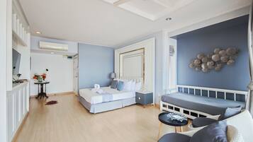 A modern hotel room with a bed, seating area, and a dining table.