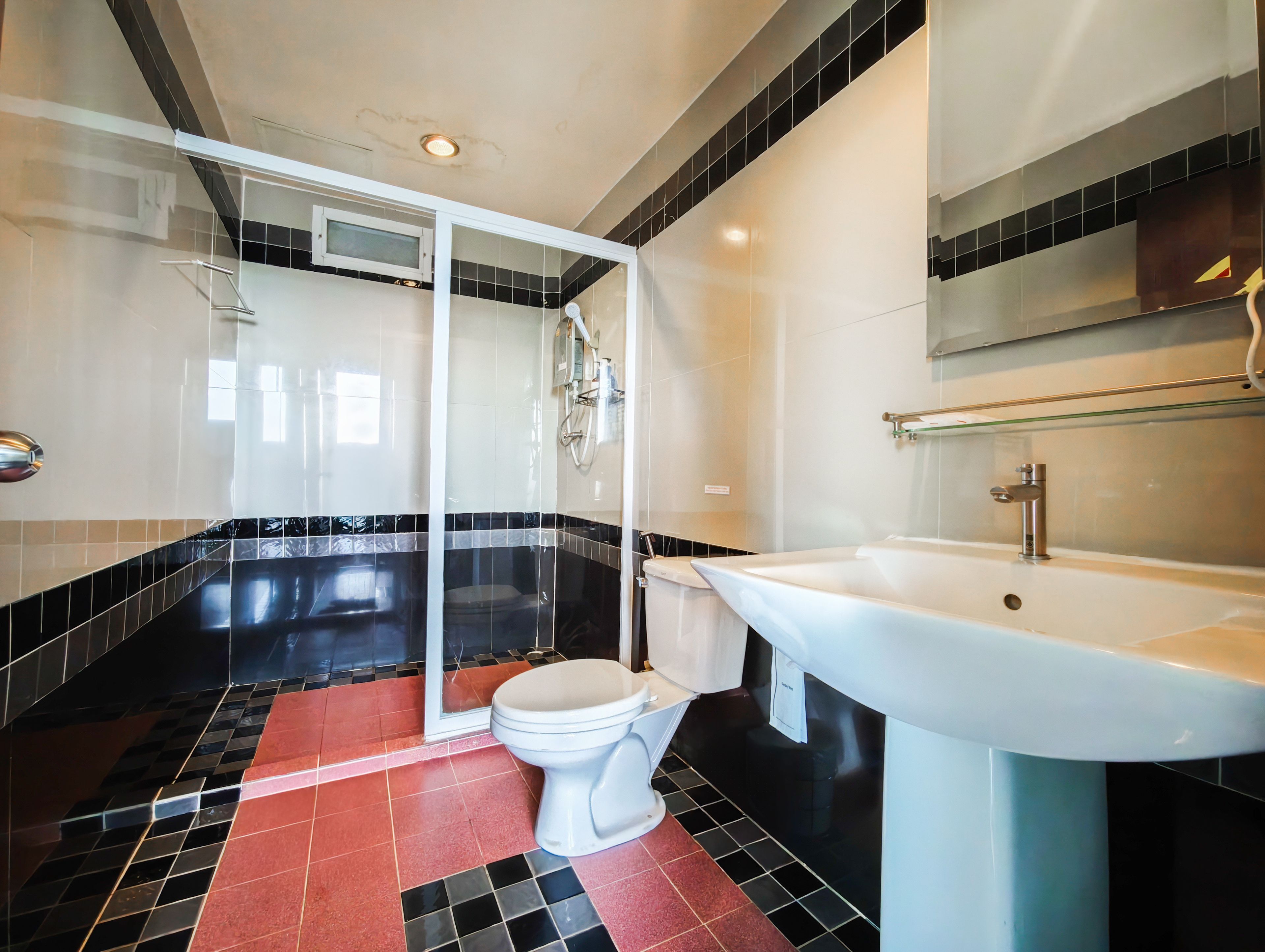 Ein modernes Badezimmer mit einer gläsernen Duschkabine, einem weißen Waschbecken und einer Toilette.