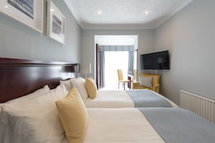 Een hotelkamer met twee bedden, een televisie en een stoel.