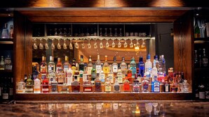 A bar with a variety of liquor bottles and glasses.