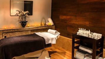 Relax in a serene spa room with a massage table, wall-mounted mirror, and soothing ambiance.